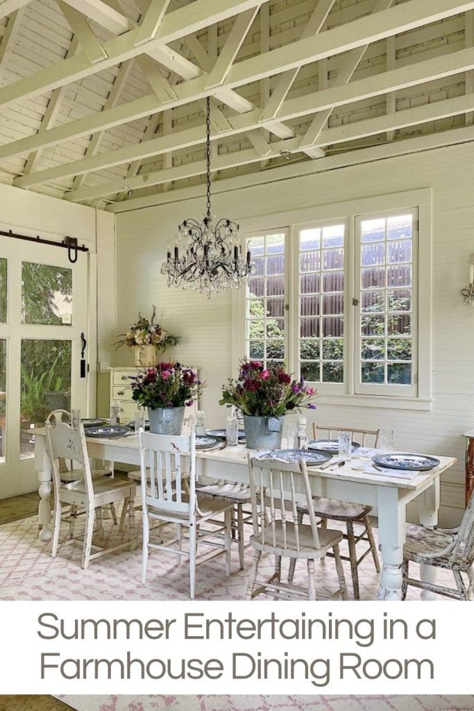 A farmhouse dining table set for dinner inside a white Carriage House.