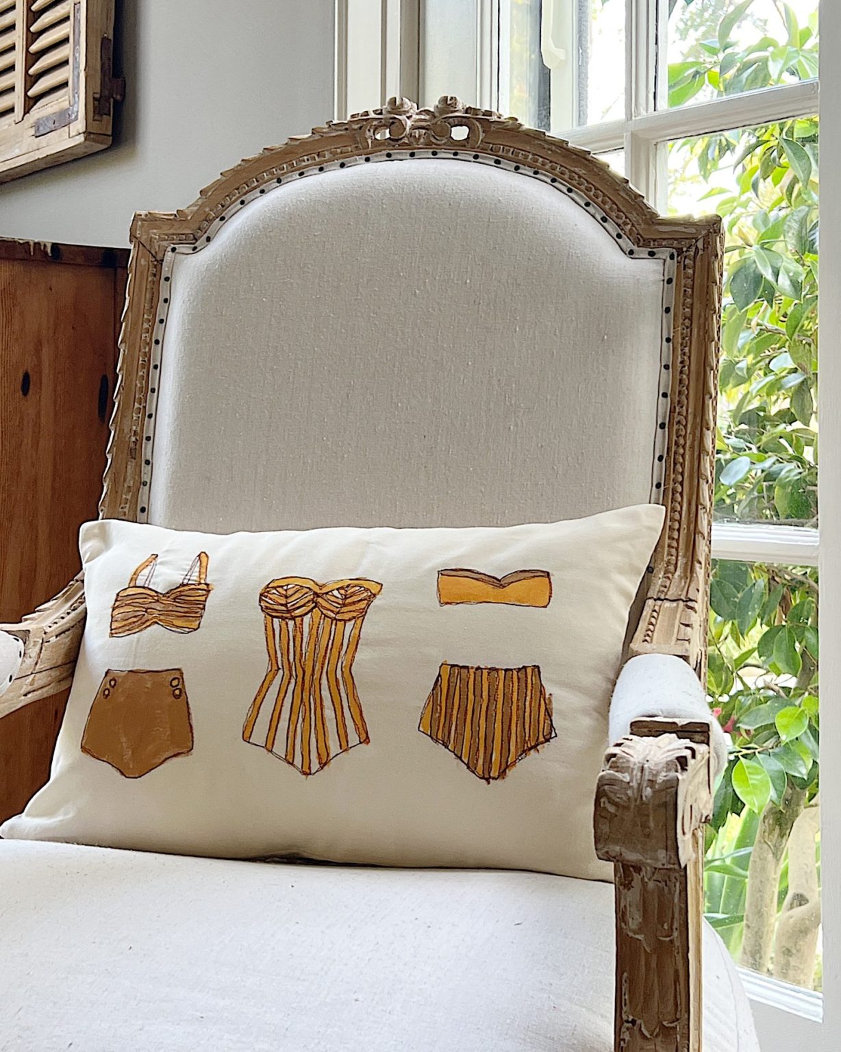 DIY pillow featuring painted and stitched vintage bathing suites in a modern coastal vintage style.