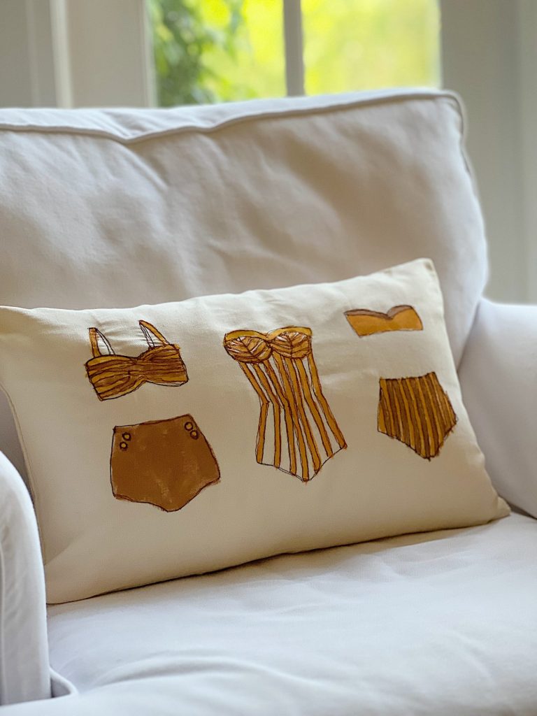 DIY pillow featuring painted and stitched vintage bathing suites in a modern coastal vintage style.