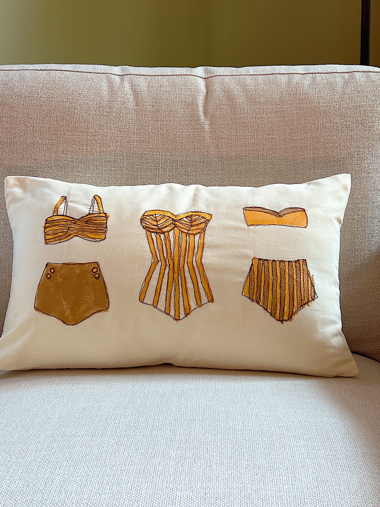 DIY pillow featuring painted and stitched vintage bathing suites in a modern coastal vintage style.