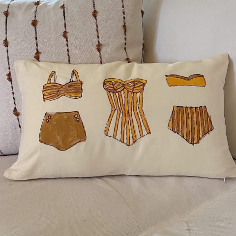 DIY pillow featuring painted and stitched vintage bathing suites in a modern coastal vintage style.