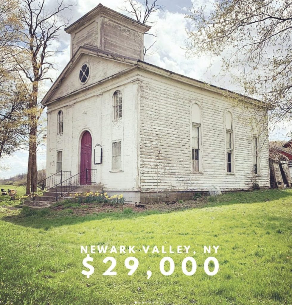 A beautiful old church in need of repair sits in a grassy lot. The church is advertised for sale for $29,000 and is in Newarlk Valley, NY
