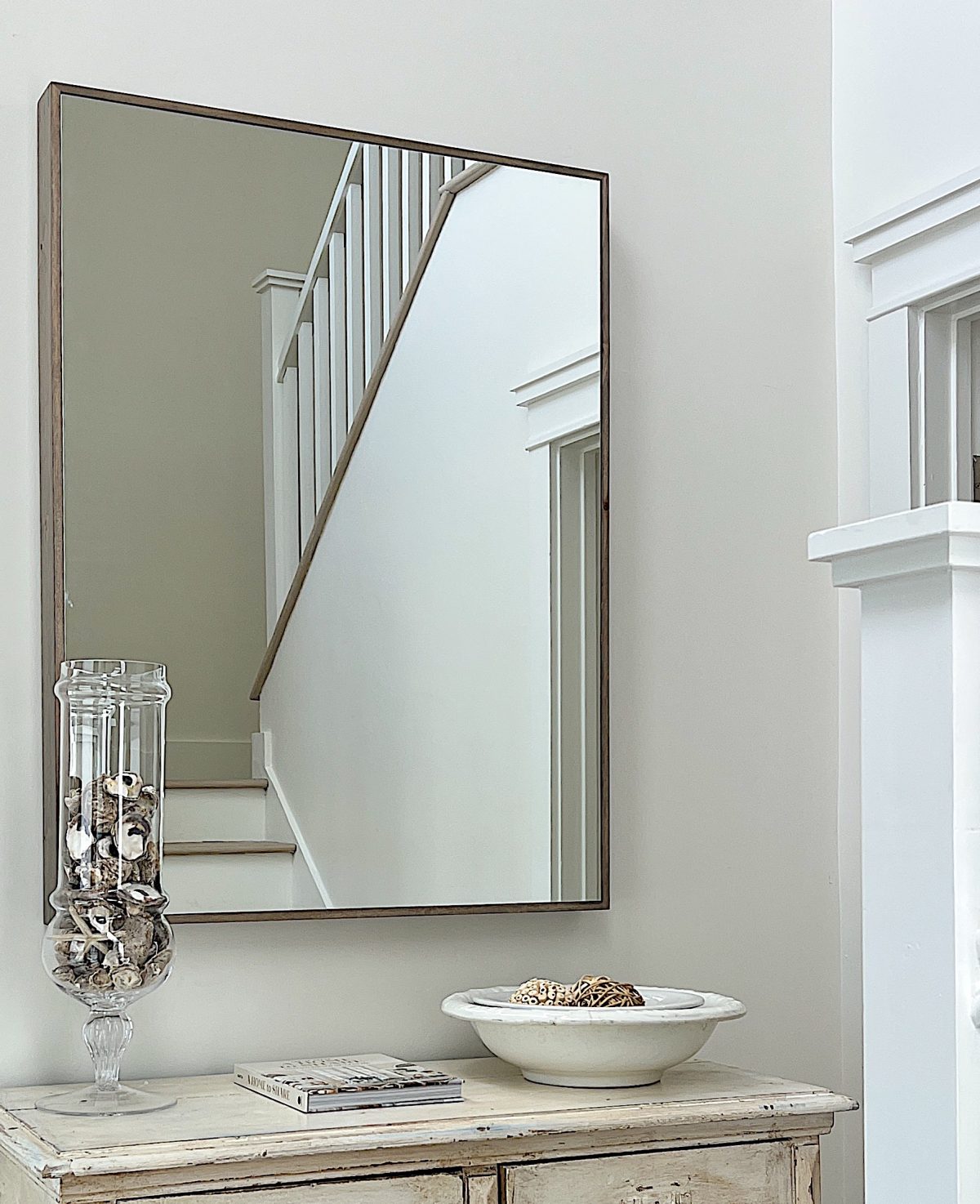 vintage items and a mirror in the entry way.