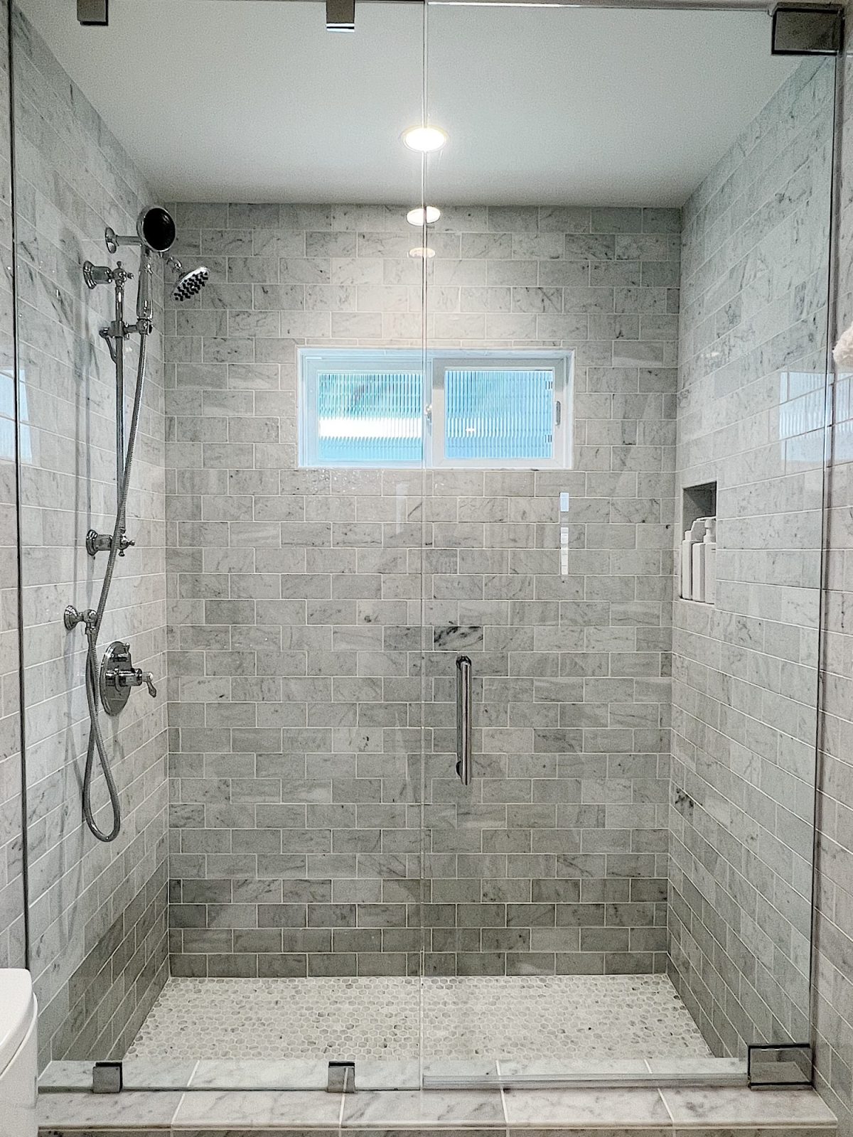 A newly constructed en suite bathroom with a step in steam shower 9with tub), single marble vanity and decor.