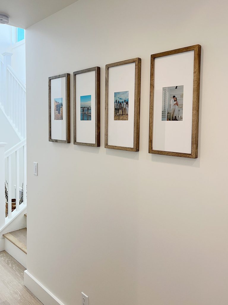 Four wood picture frames hanging on the wall of our beach house.