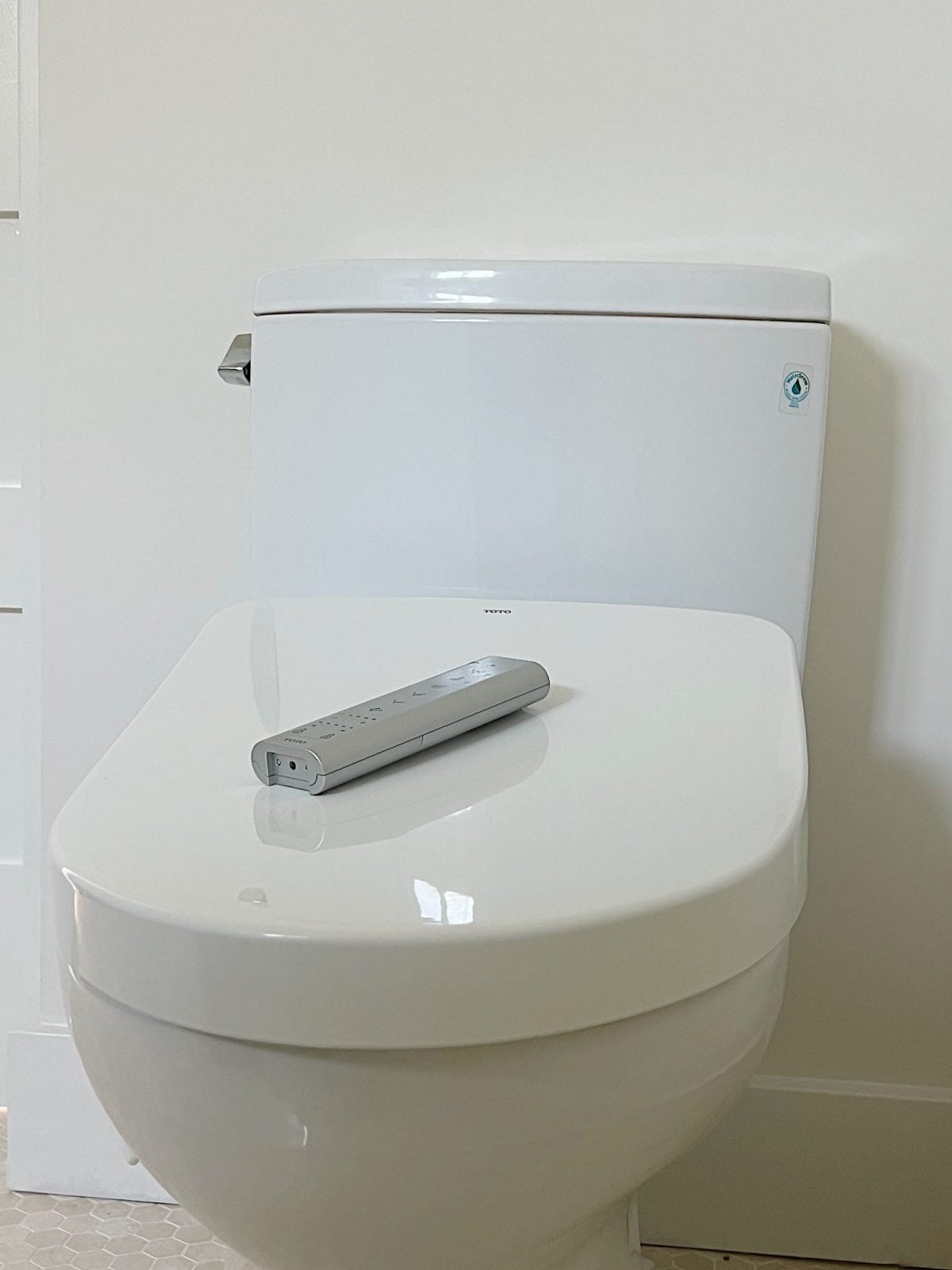 A newly constructed primary bathroom with a double sink vanity, marble tile shower, and Toto bidet toilet.