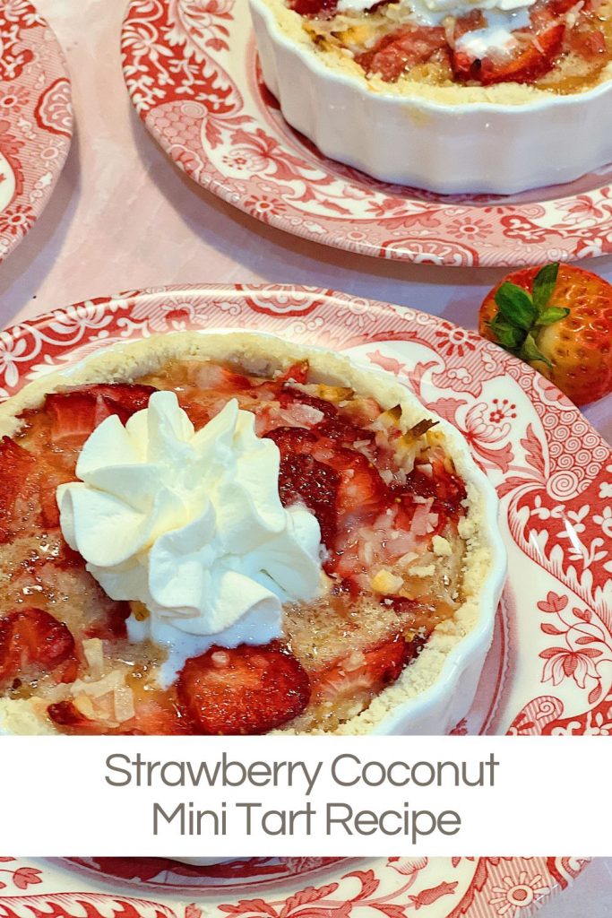 A homemade strawberry coconut tart with a delicious crust and whip cream dollop served in a white tart pan on a red and white plate.