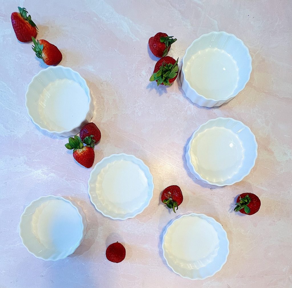A mini white tart pan with fresh strawberries.
