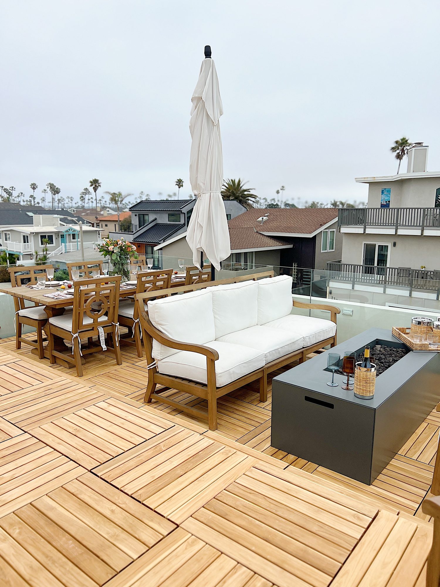 The deck on our third floor with Arhaus furniture, a fire pit, and dinner decor items.