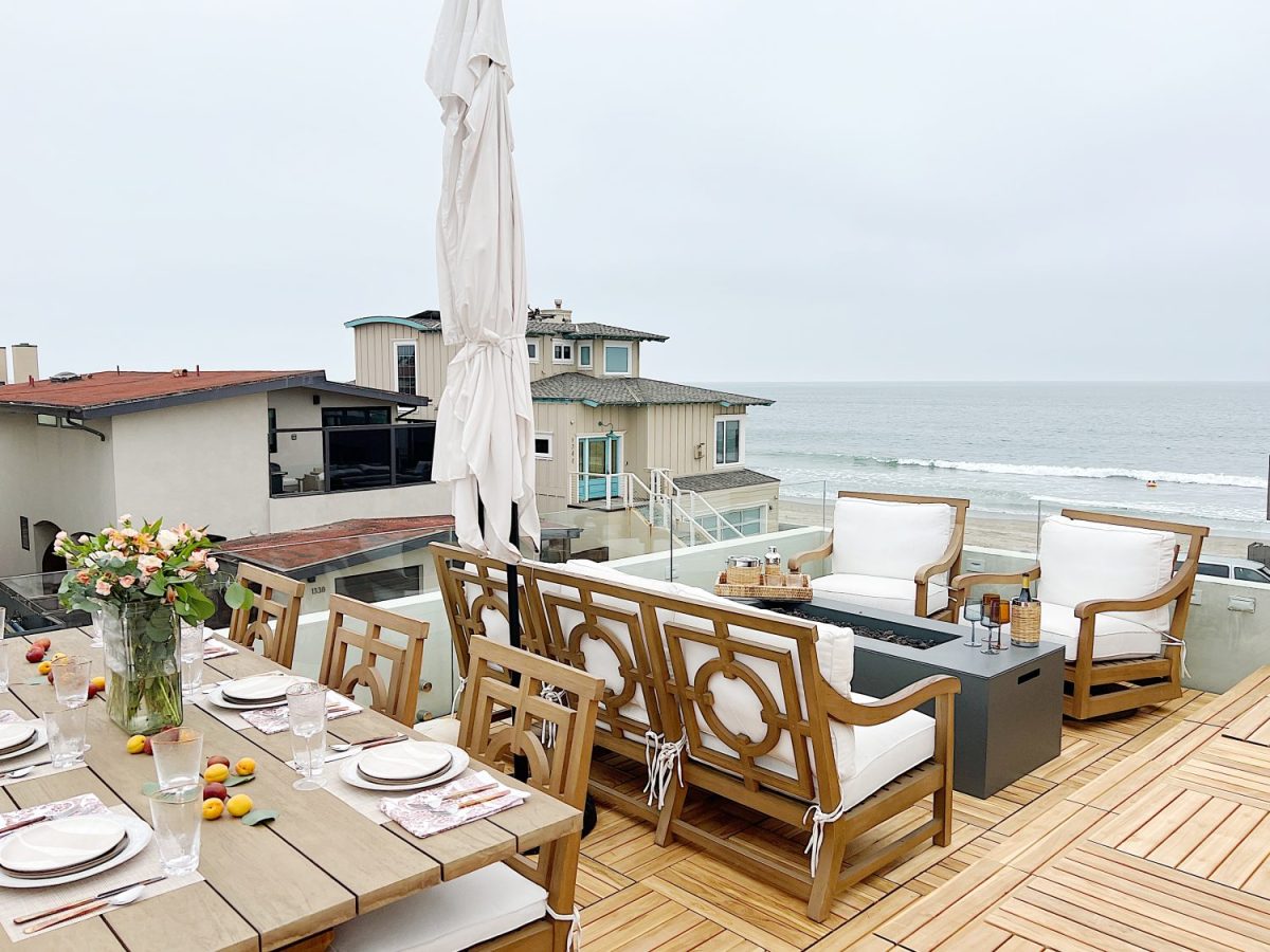The deck on our third floor with Arhaus furniture, a fire pit, and dinner decor items.