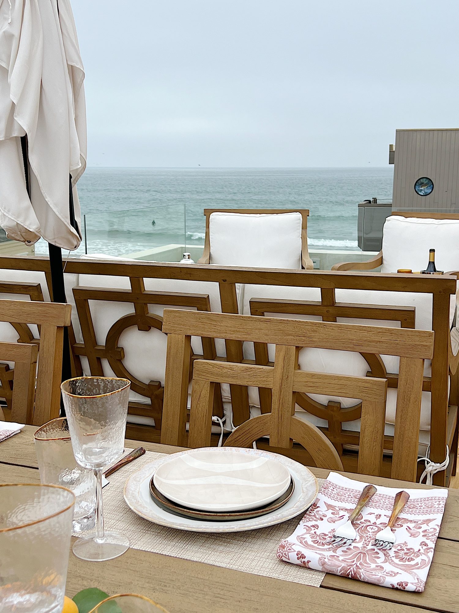 The deck on our third floor with Arhaus furniture, a fire pit, and dinner decor items.