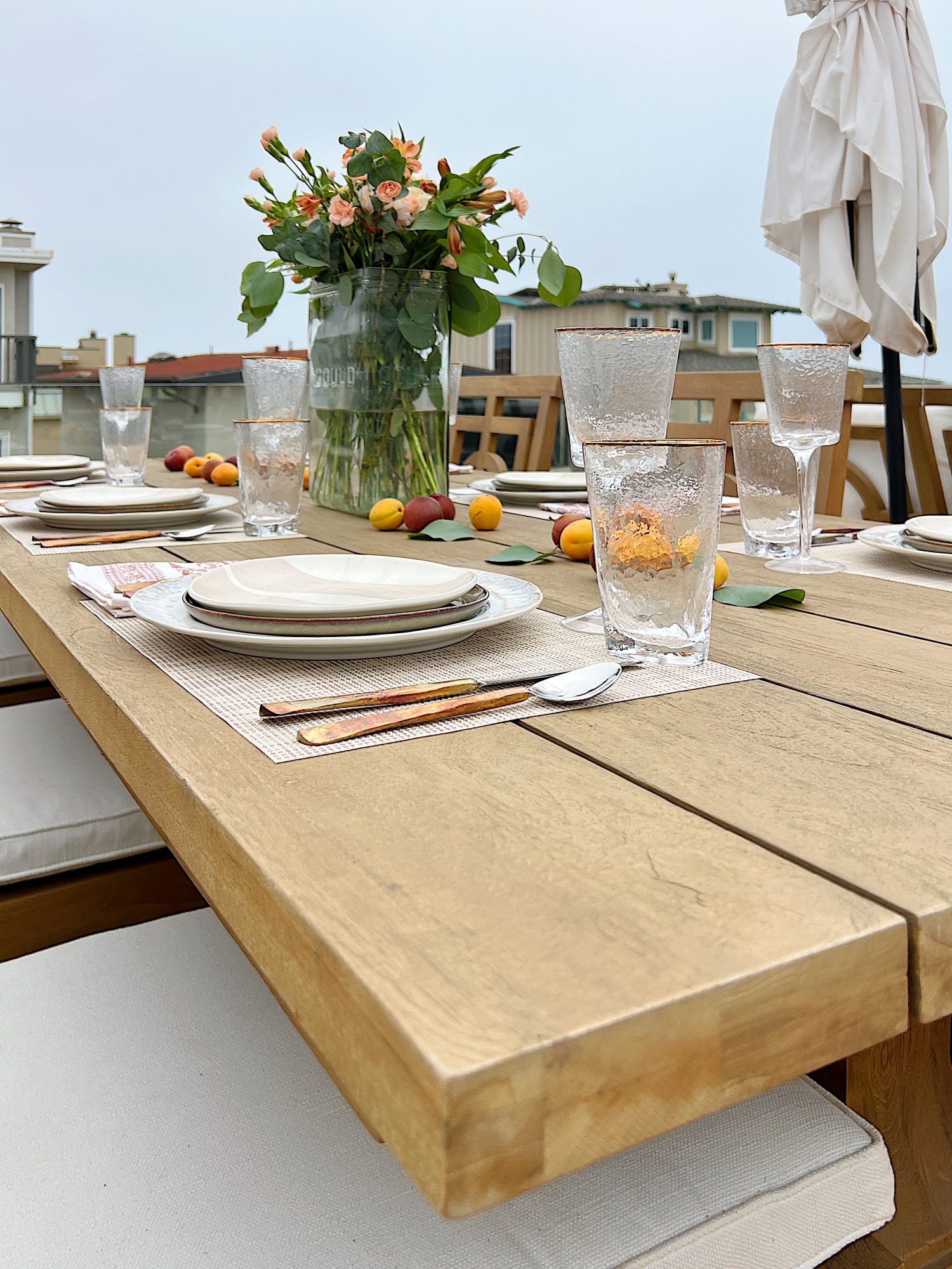 The deck on our third floor with Arhaus furniture, a fire pit, and dinner decor items.