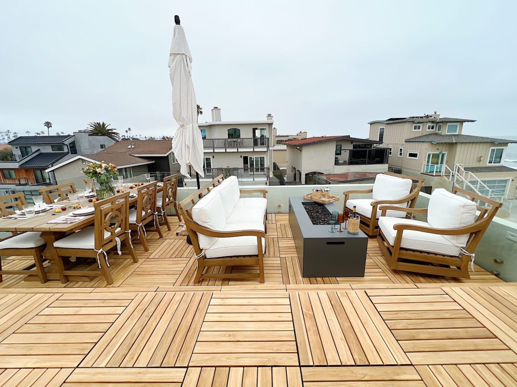 The deck on our third floor with Arhaus furniture, a fire pit, and dinner decor items.