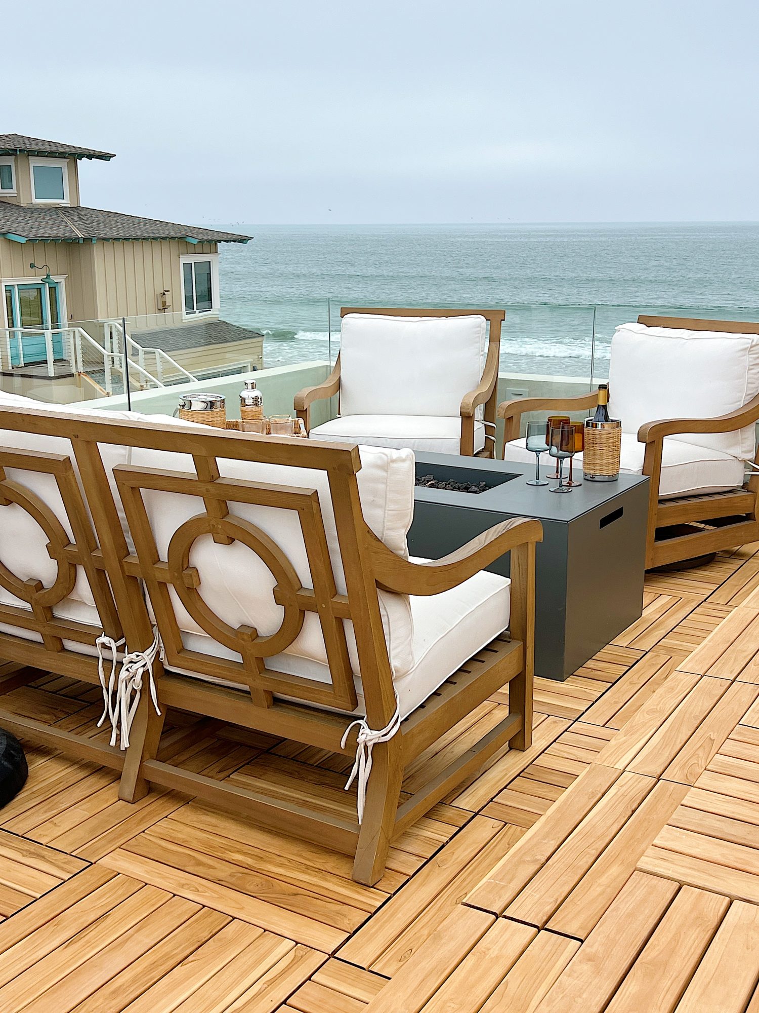 The deck on our third floor with Arhaus furniture, a fire pit, and dinner decor items.