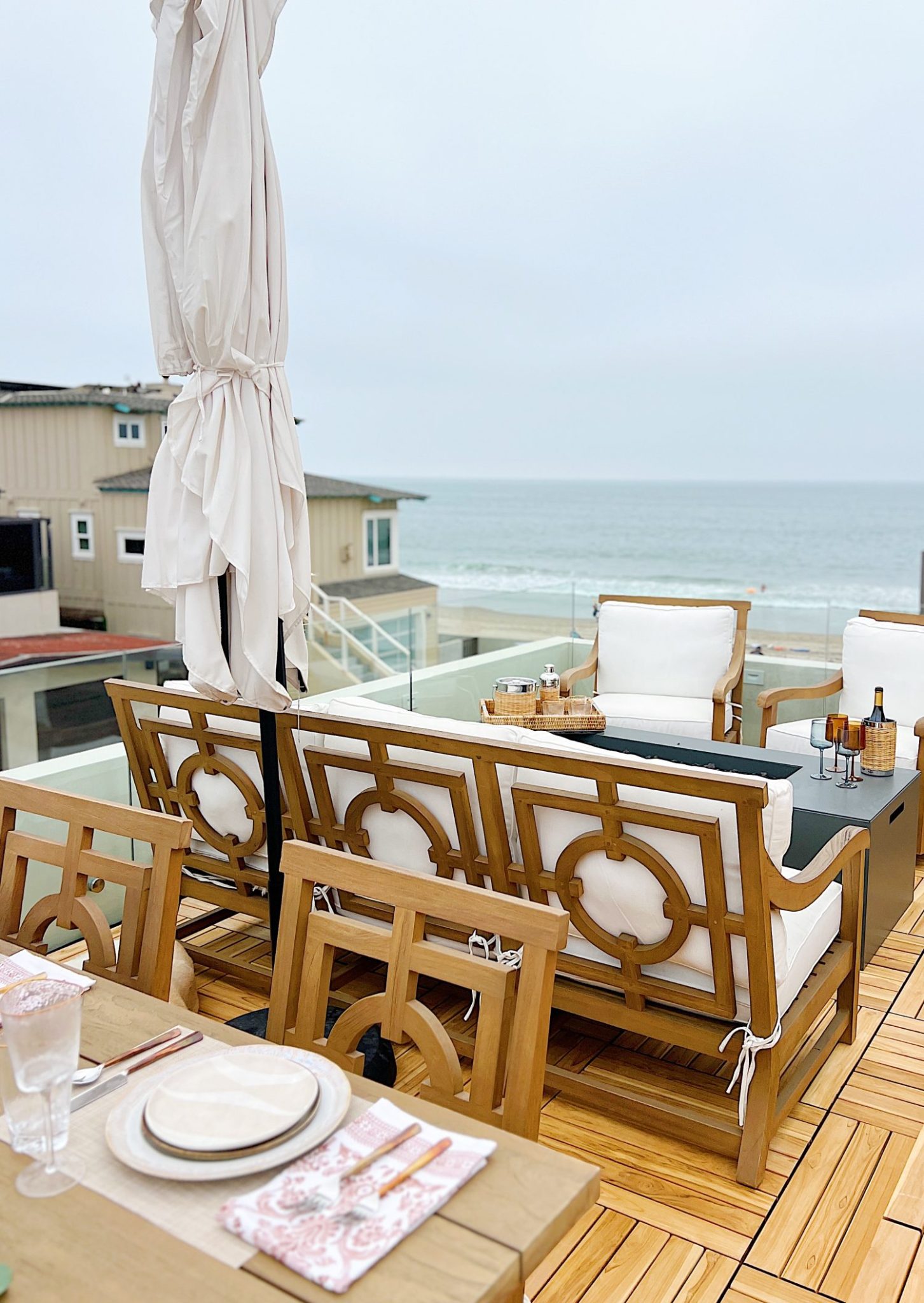 The deck on our third floor with Arhaus furniture, a fire pit, and dinner decor items.