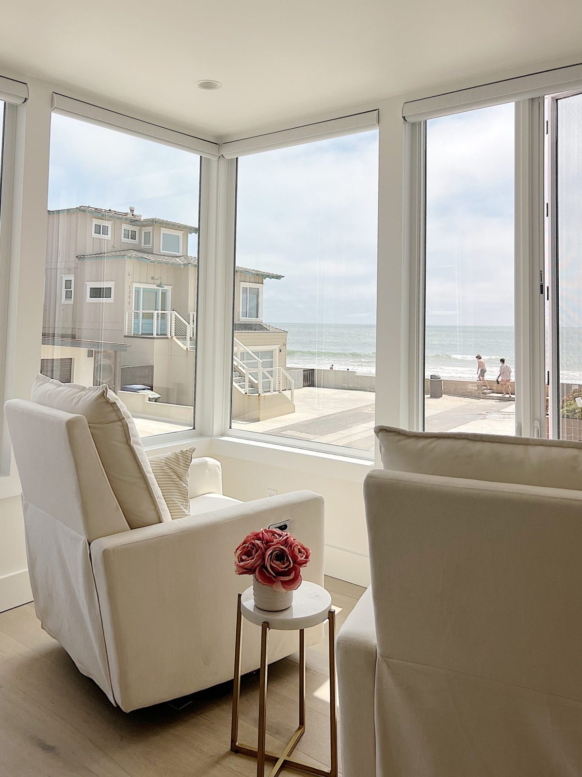 The primary bedroom in our beach house with five windows and an ocean view.