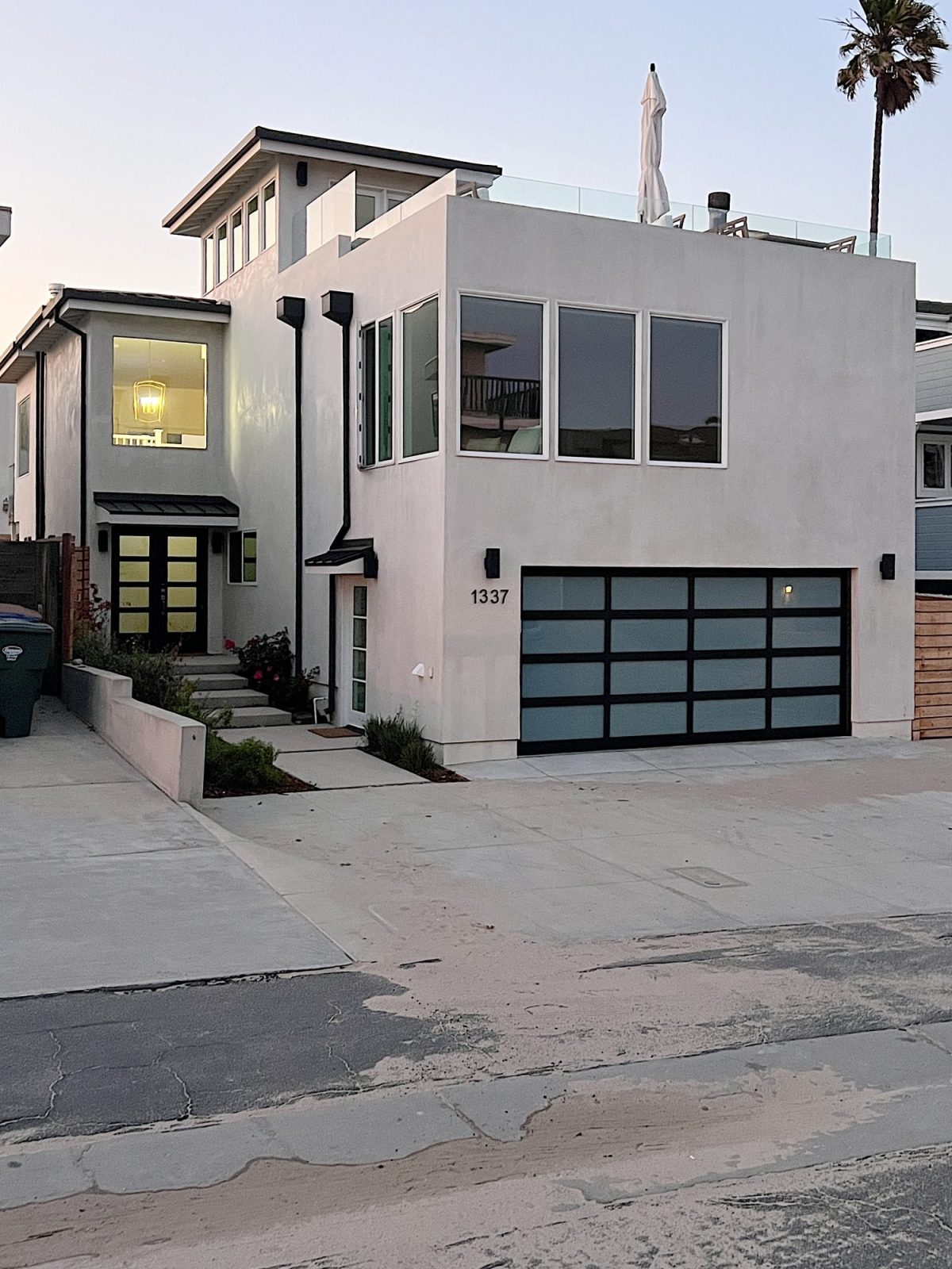 The remodeled exterior of our beach house with new windows, plaster finish and new front and garage doors.