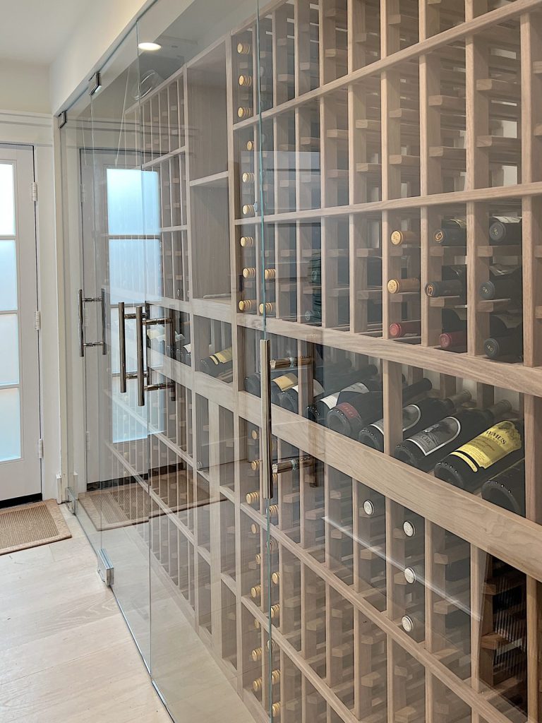 A built in wine cellar at the beach in a hallway.
