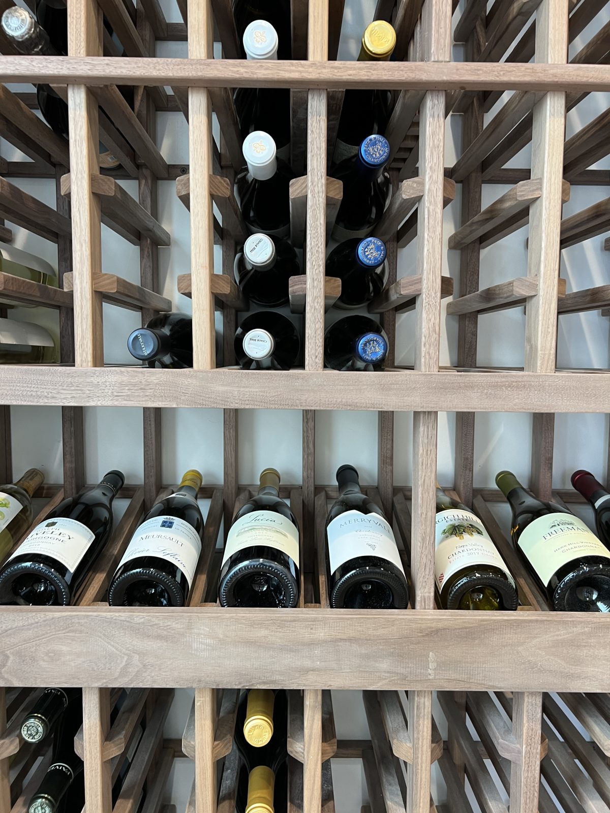 A built in wine cellar at the beach in a hallway.