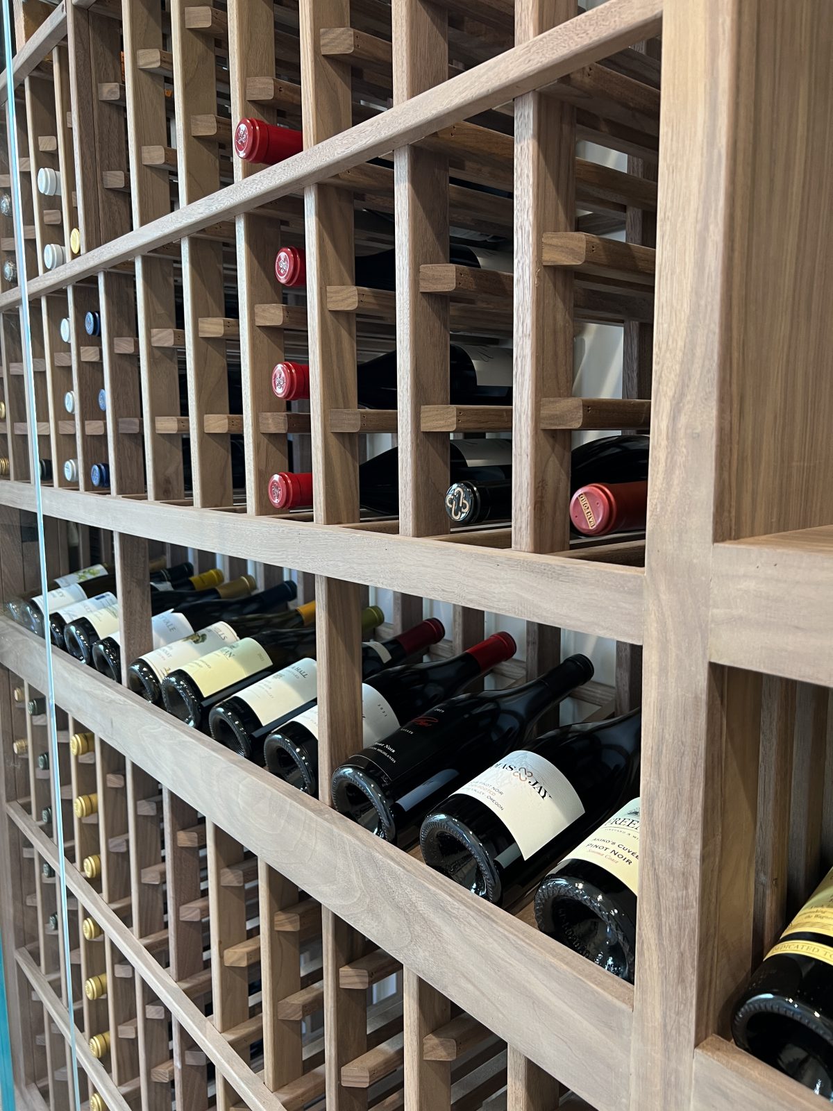 A built in wine cellar at the beach in a hallway.