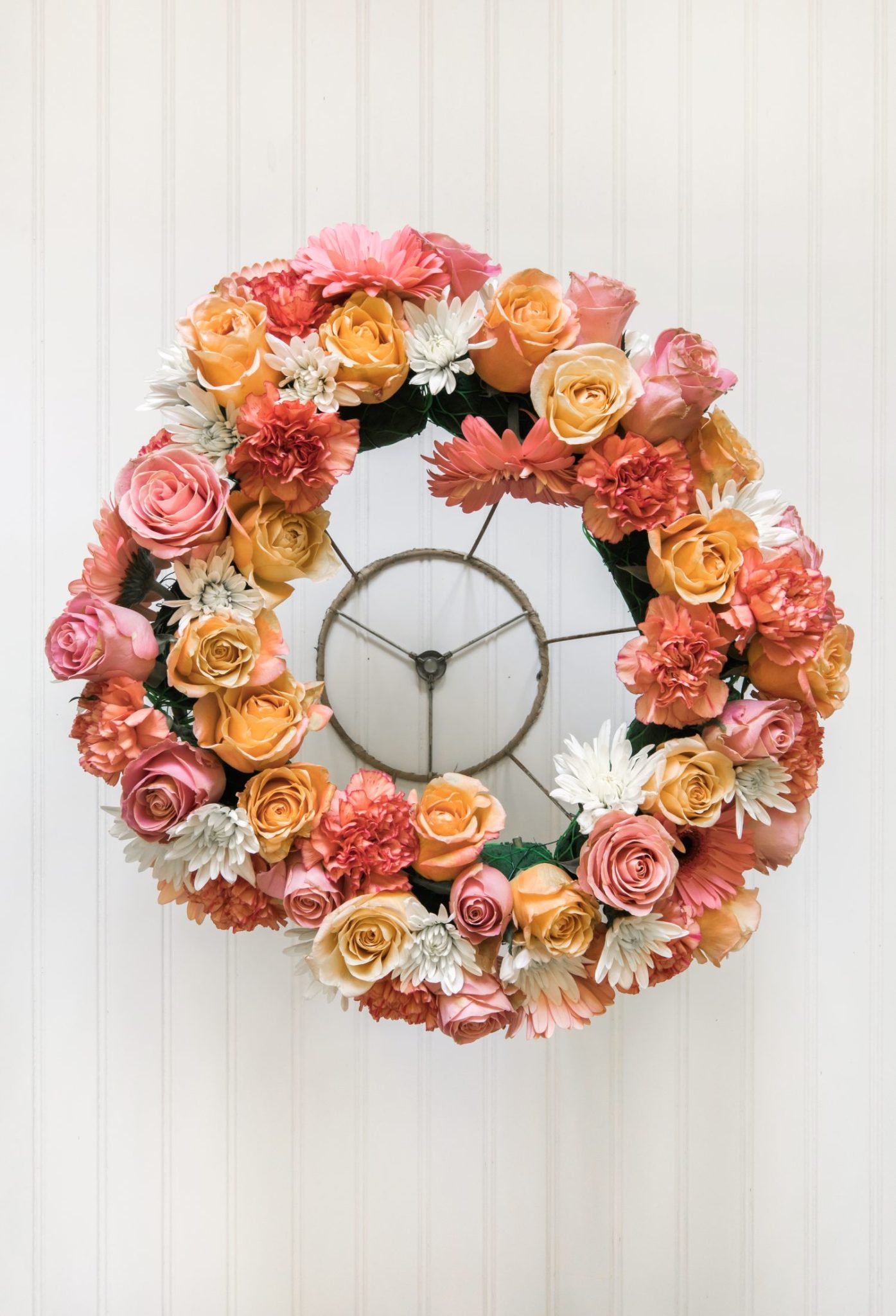A handmade flower crown made from a vintage lampshade, oasis, and fresh flowers hanging on top of a magical table set for 40 guests.
