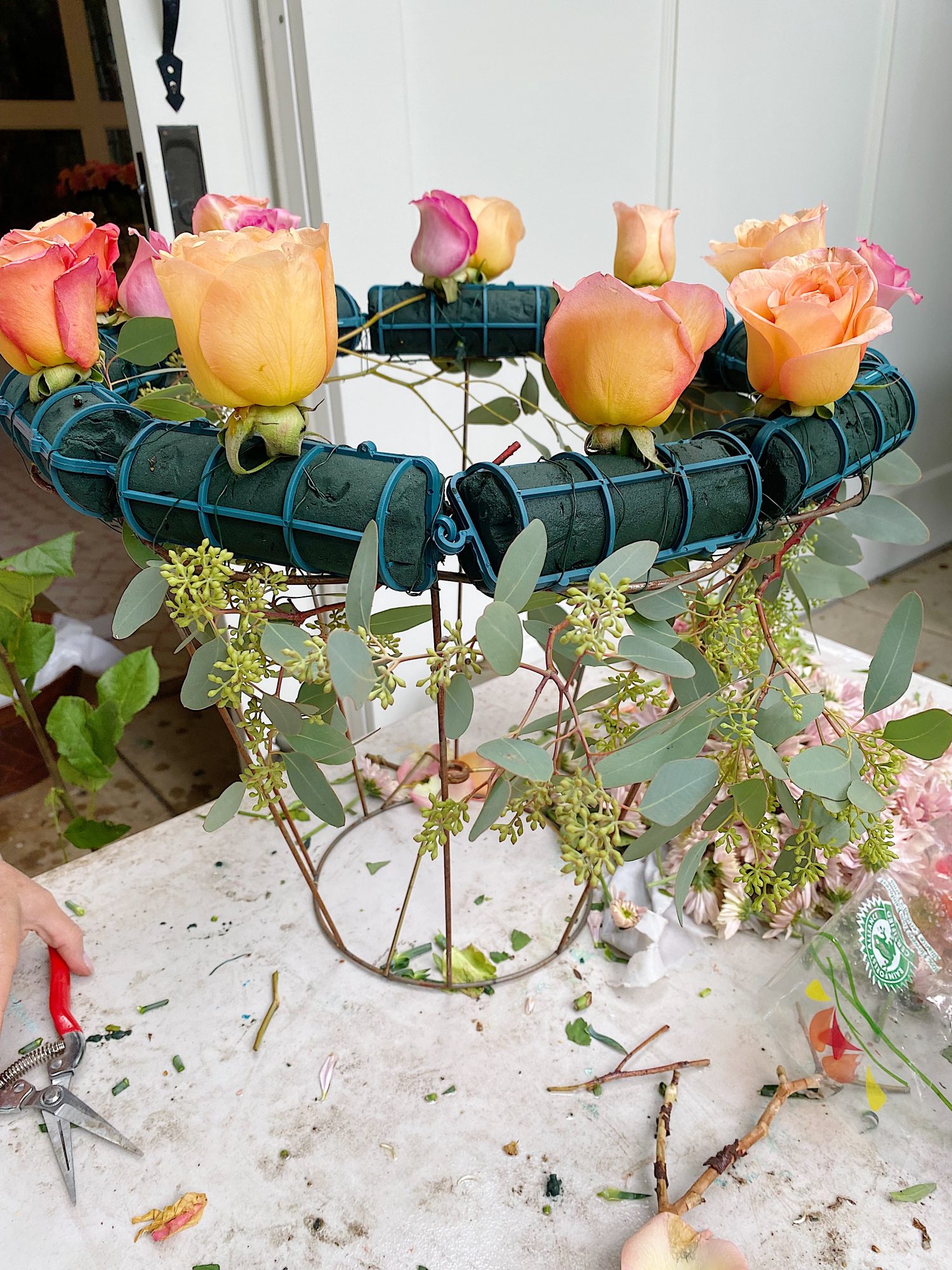 A handmade flower crown made from a vintage lampshade, oasis, and fresh flowers hanging on top of a magical table set for 40 guests.