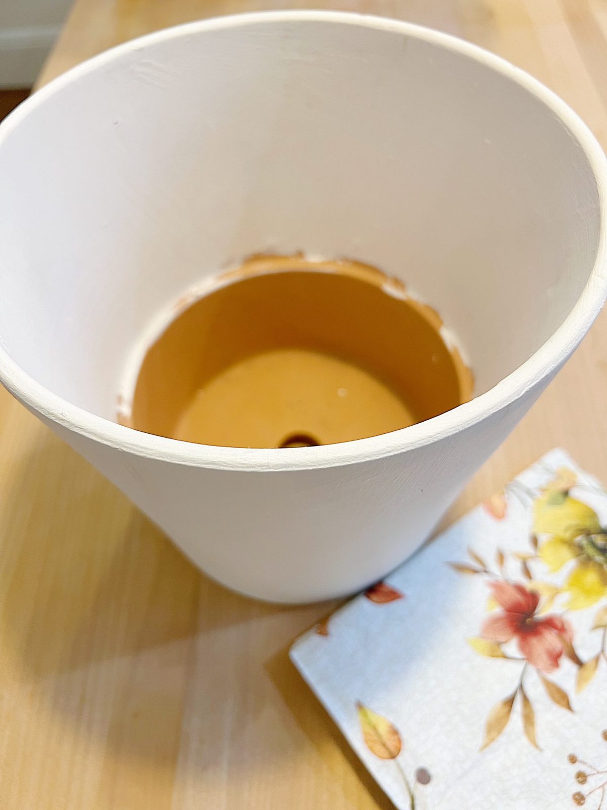 How to cover a terra cotta pot with a paper napkin.