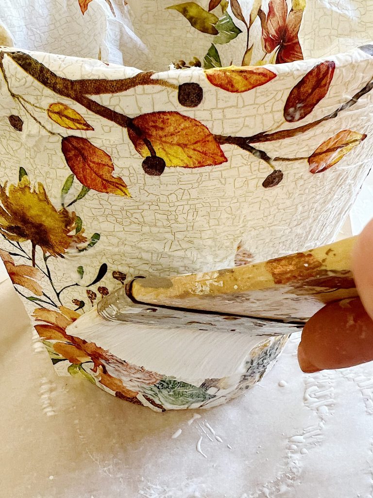 How to cover a terra cotta pot with a paper napkin.