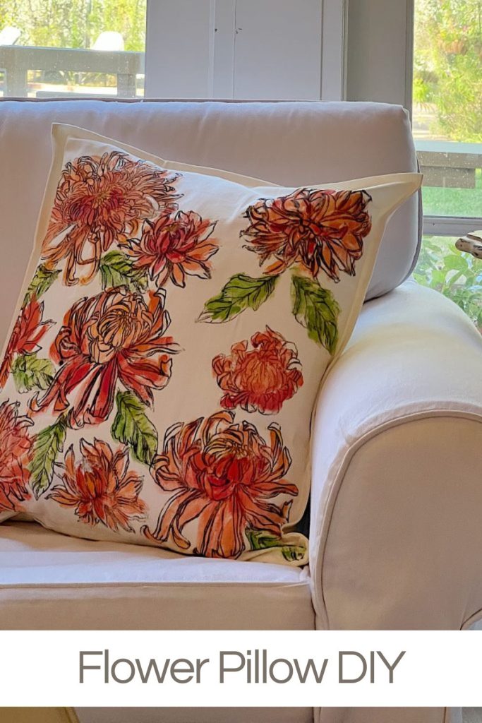 A painted and stamped summer pillow with larger orange flowers.