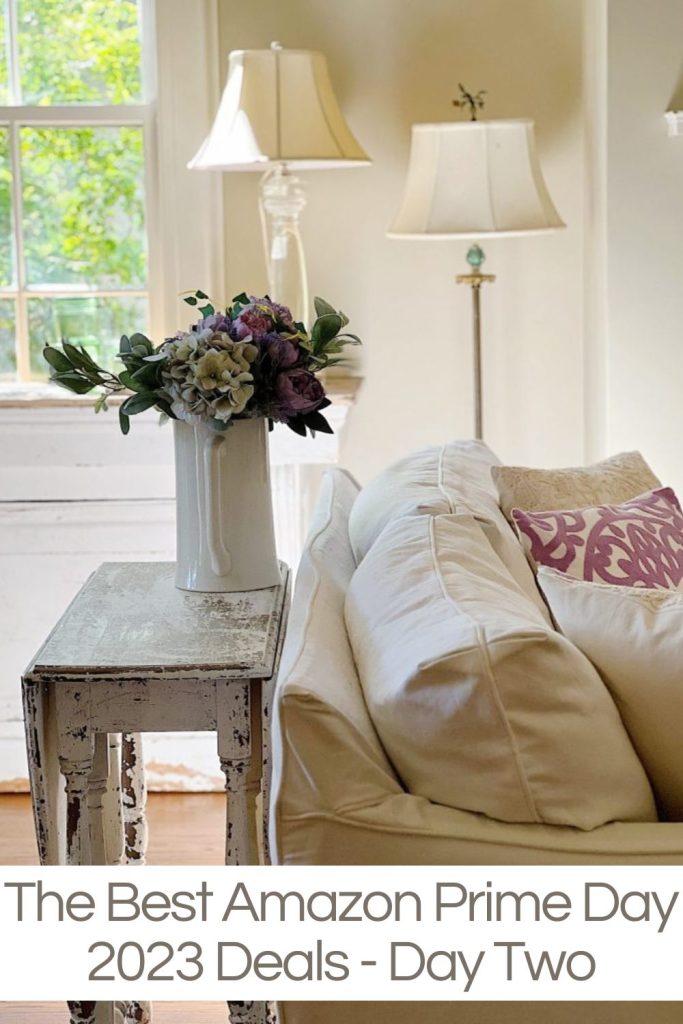 A slipcovered beige sofa, two lamps and lavender decor accents.