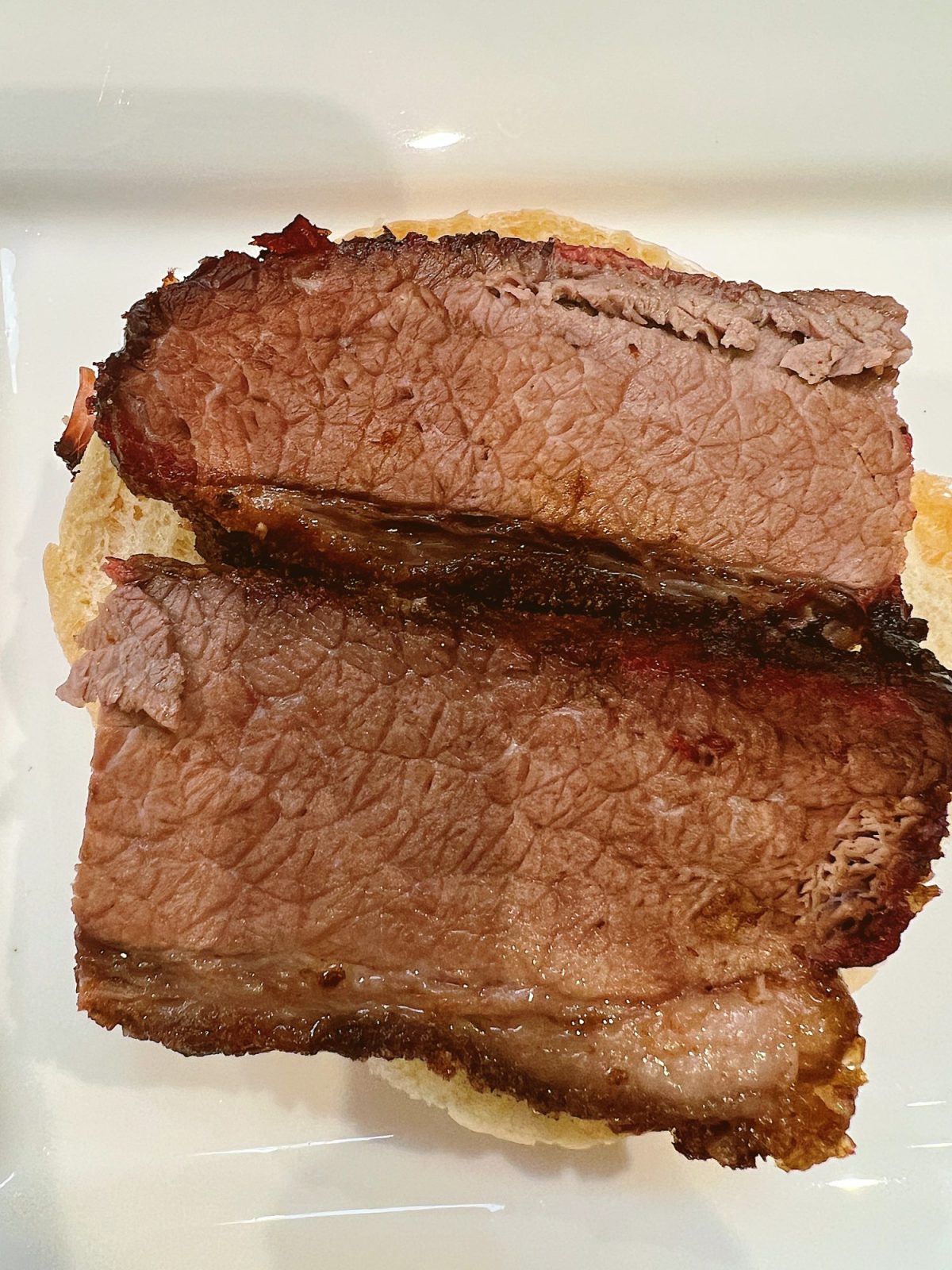 Making smoked brisket sandwiches with barbecue sauce and coleslaw.