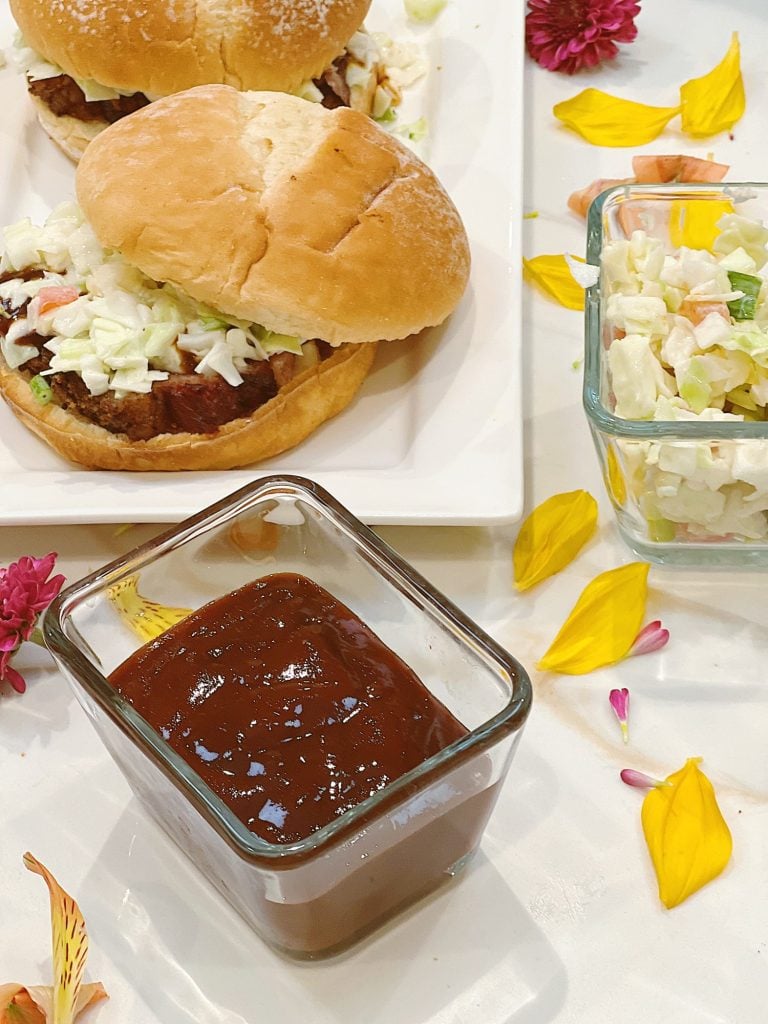 Making smoked brisket sandwiches with barbecue sauce and coleslaw.