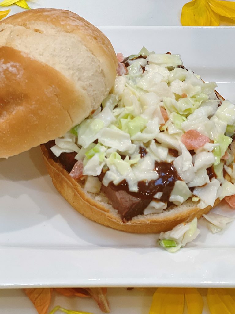 Making smoked brisket sandwiches with barbecue sauce and coleslaw.