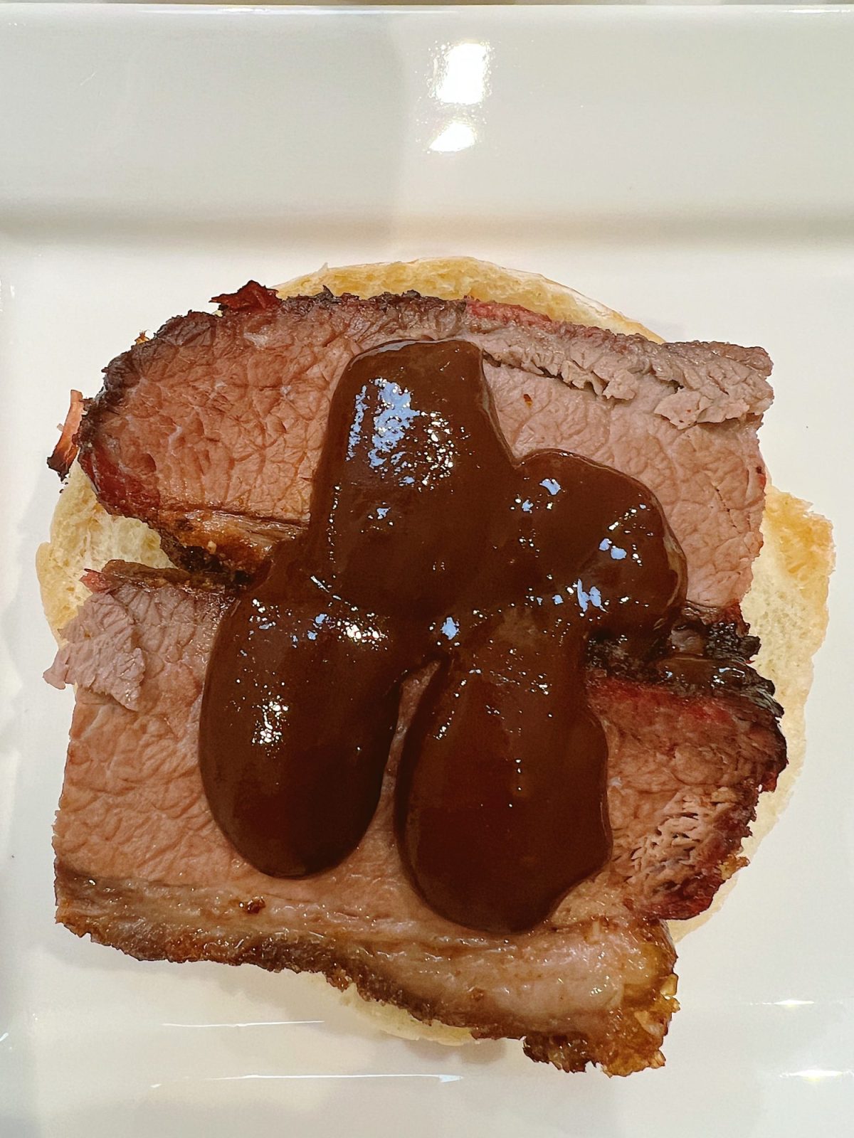 Making smoked brisket sandwiches with barbecue sauce and coleslaw.