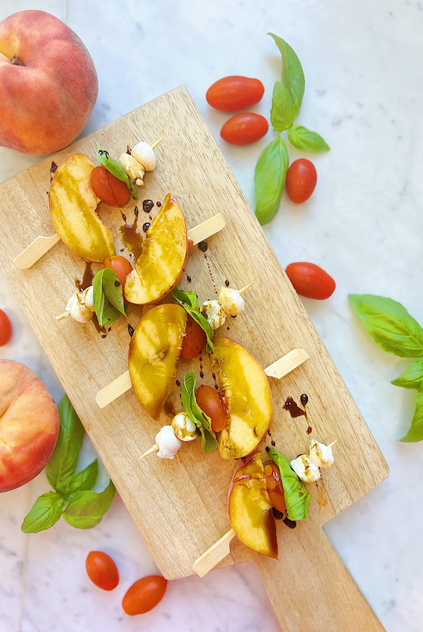 Skewers of peaches, tomato, basil and mozarella, with a balsamic glaze.