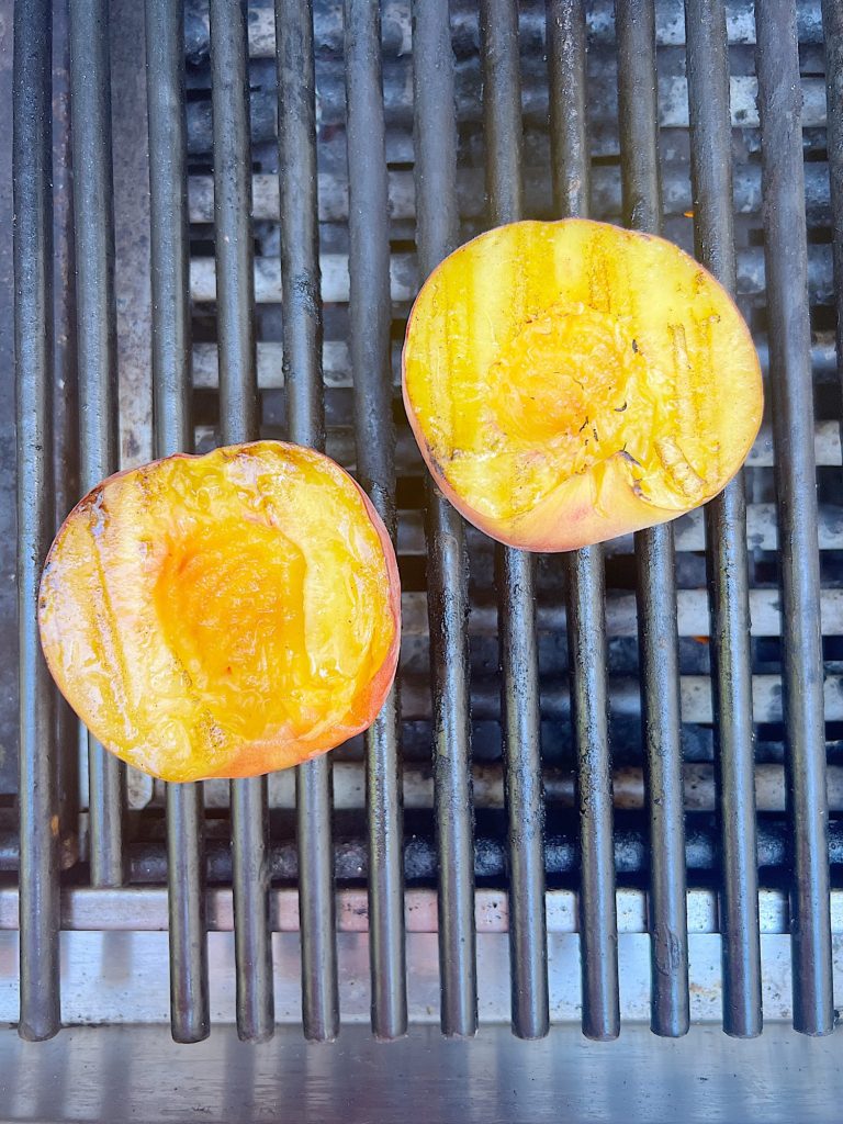 Grilling two peach halves.