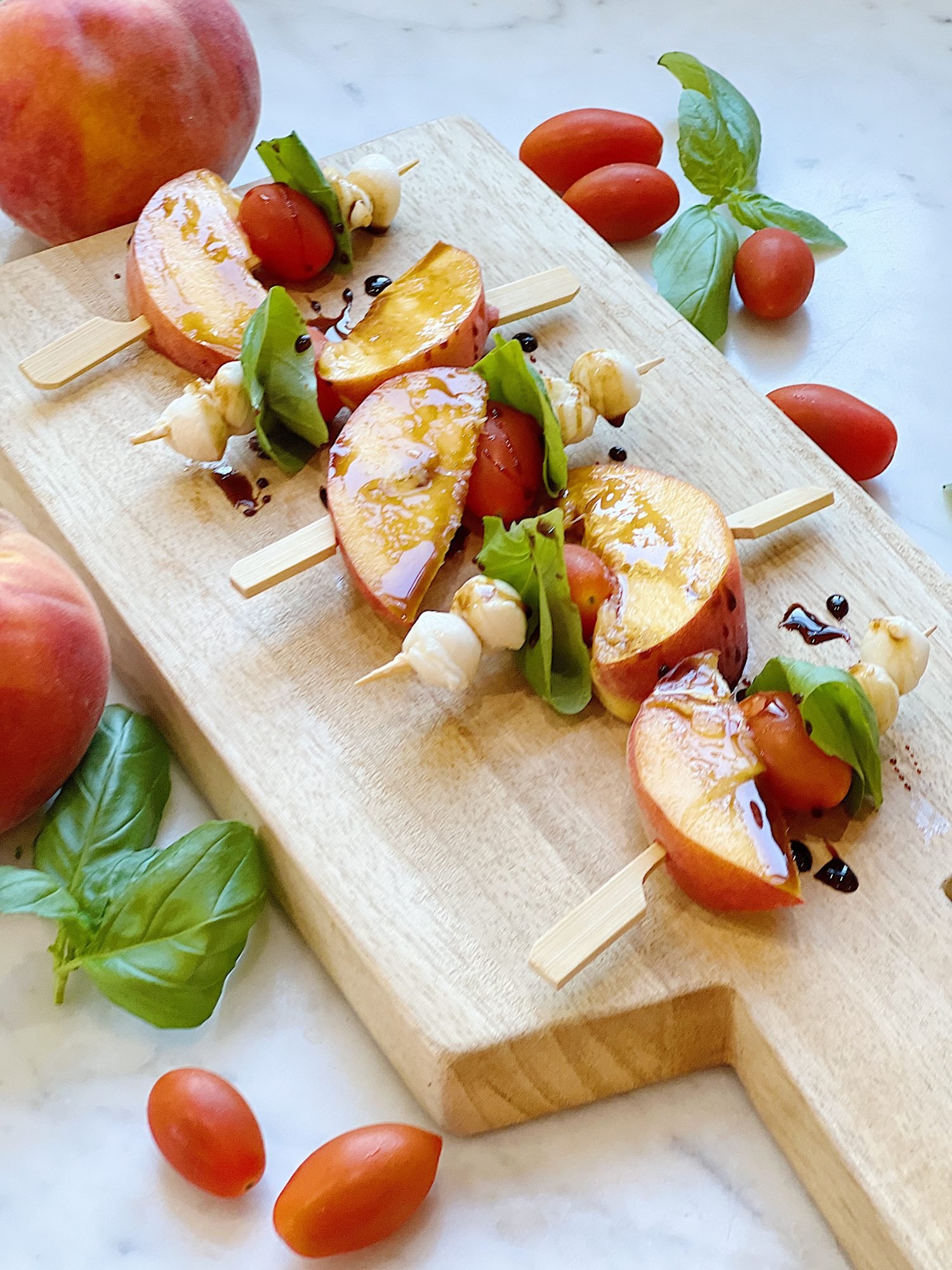 Skewers of peaches, tomato, basil and mozarella, with a balsamic glaze.