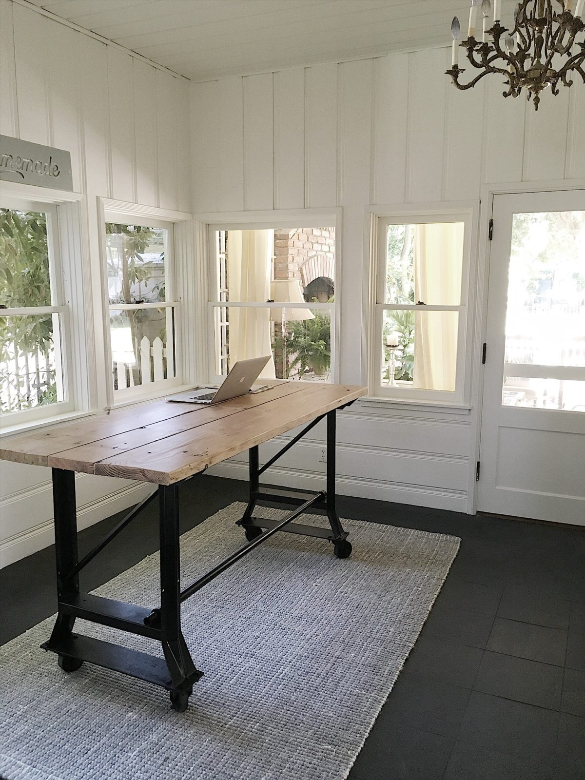 The transformation of a craft room with dark paneling to a bright white room.