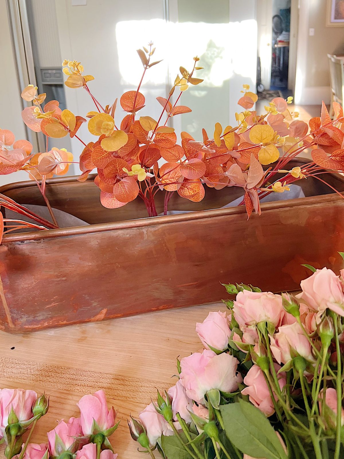 A fall table set in the dining room with pink and copper accents.