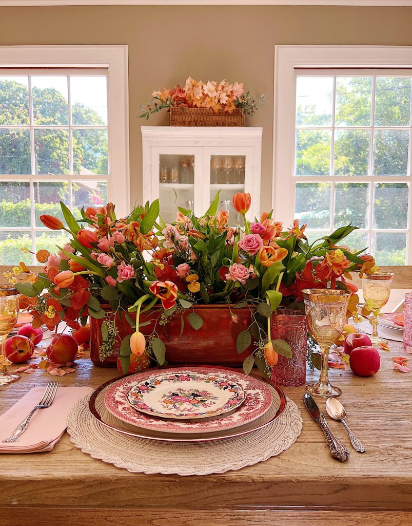 A fall table set in the dining room with pink and copper accents.