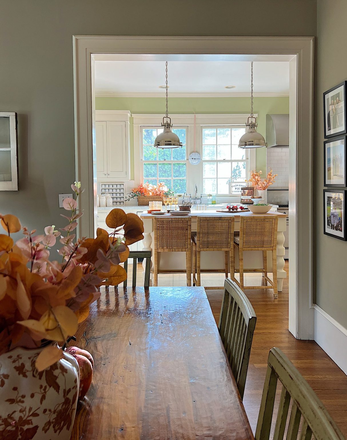 A white kitchen with an island and rattan barstools decorated with fall decor.A white kitchen with an island and rattan barstools decorated with fall decor.