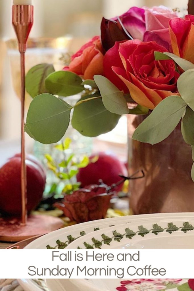 A table set for fall with roses, fall fruits, and tableware.