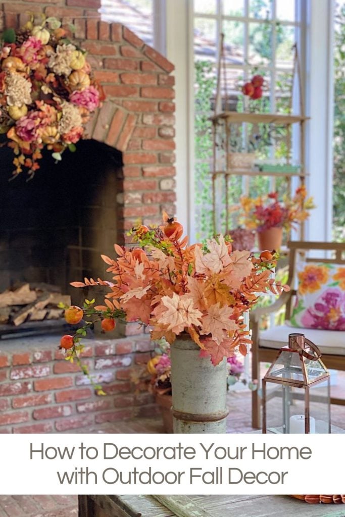 A back porch with a brick fireplace decorated with bright fall decor in orange and pink.