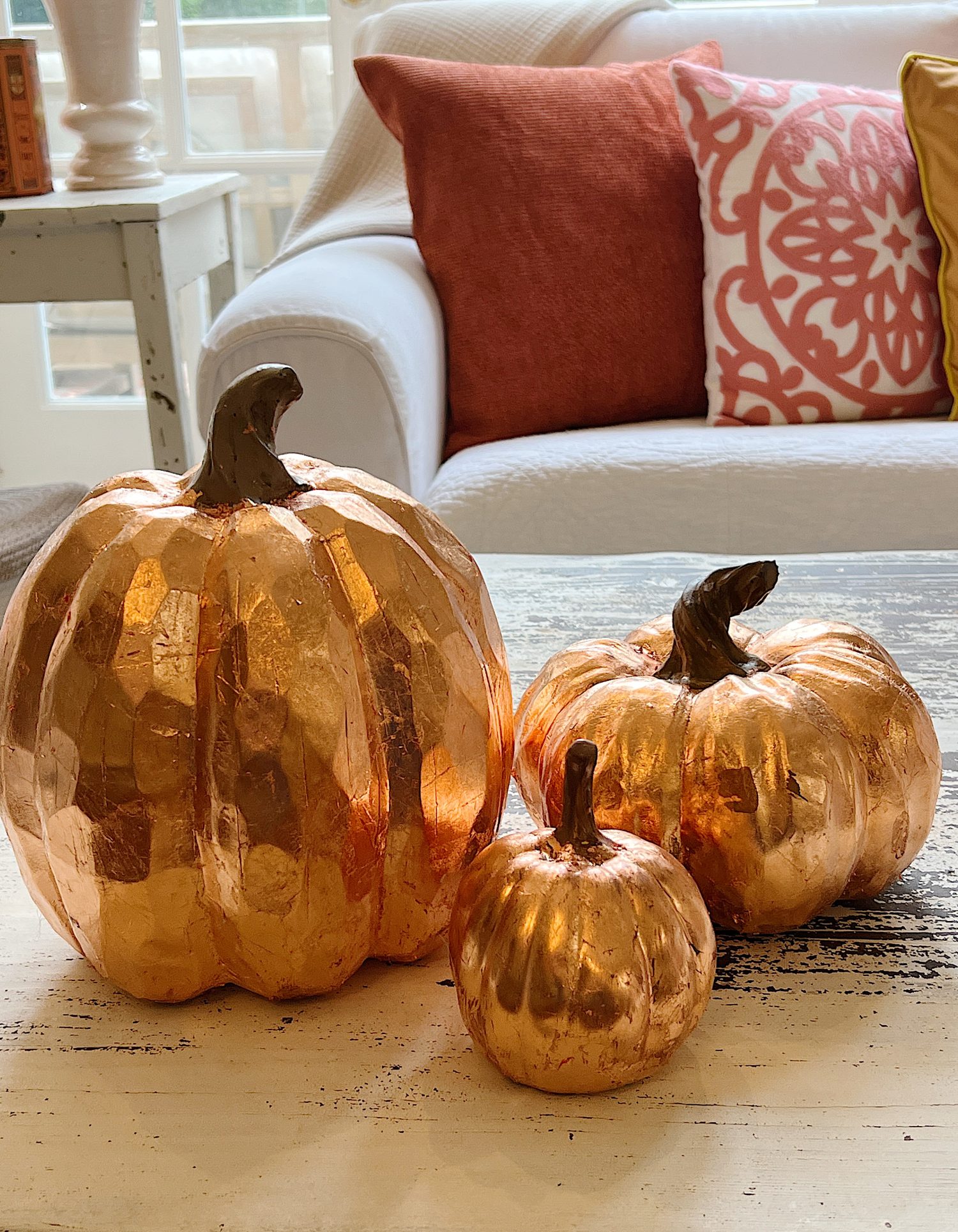 Three faux pumpkins covered with copper foil leaf.