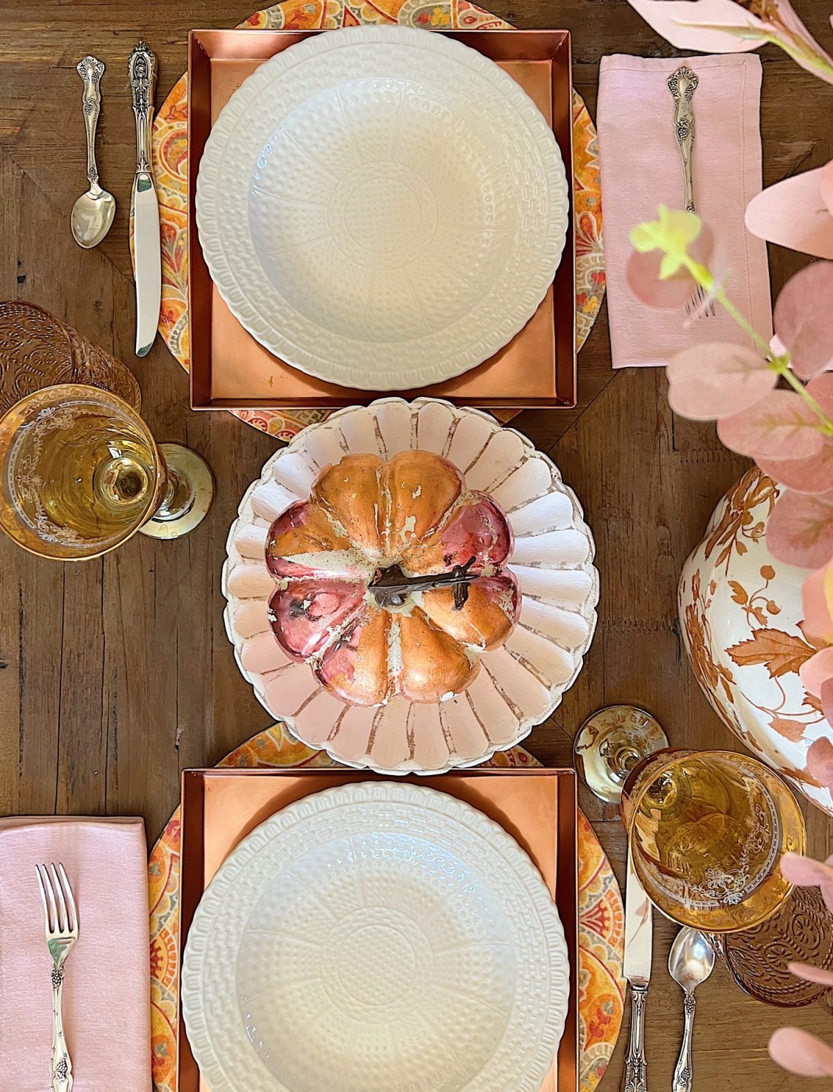 A neutral living room styled for fall with apricot, pink, and light orange florals and decor.