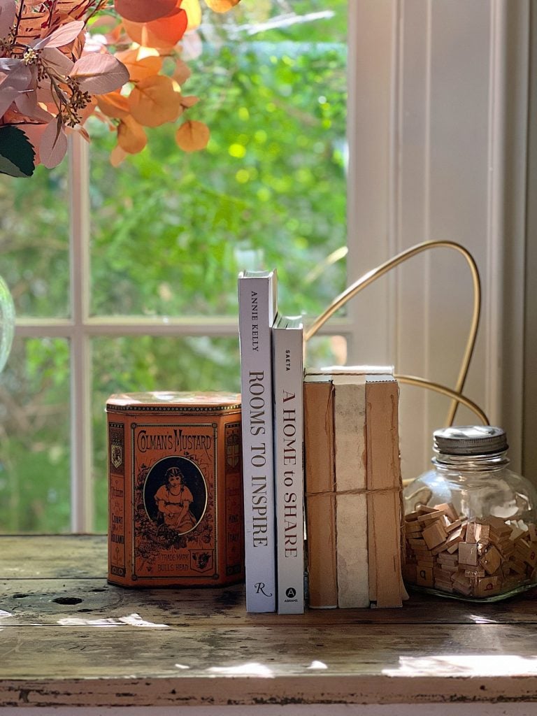 A neutral living room styled for fall with apricot, pink, and light orange florals and decor.