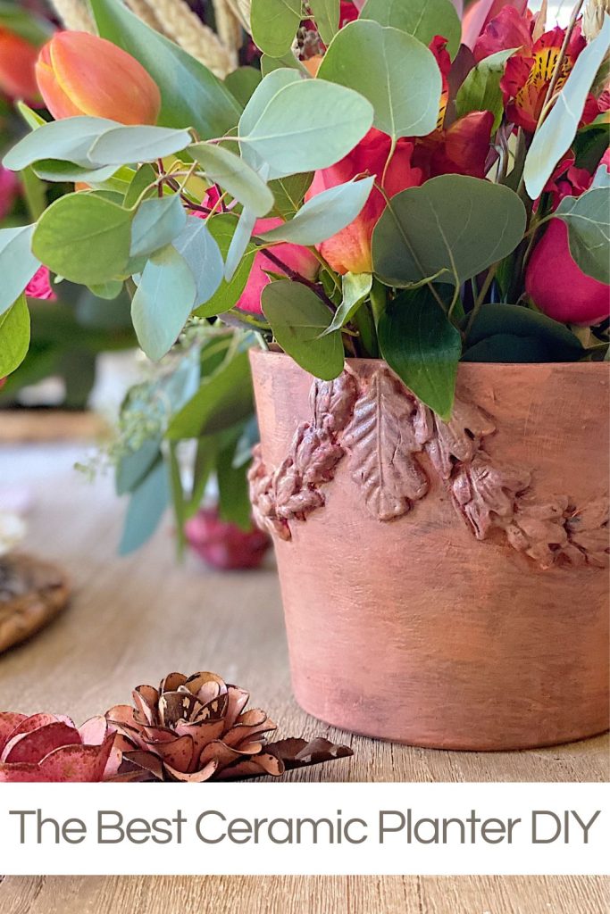 A handmade ceramic planter with fresh flowers and flower decor.