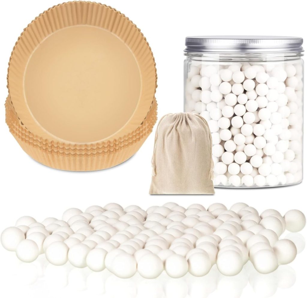 A stack of brown pie crust shields lies beside a bundle of white ceramic baking beads spilling from a small bag, ready to perfect your pear and cranberry tart. A transparent jar filled with more beads completes the baker's arsenal.