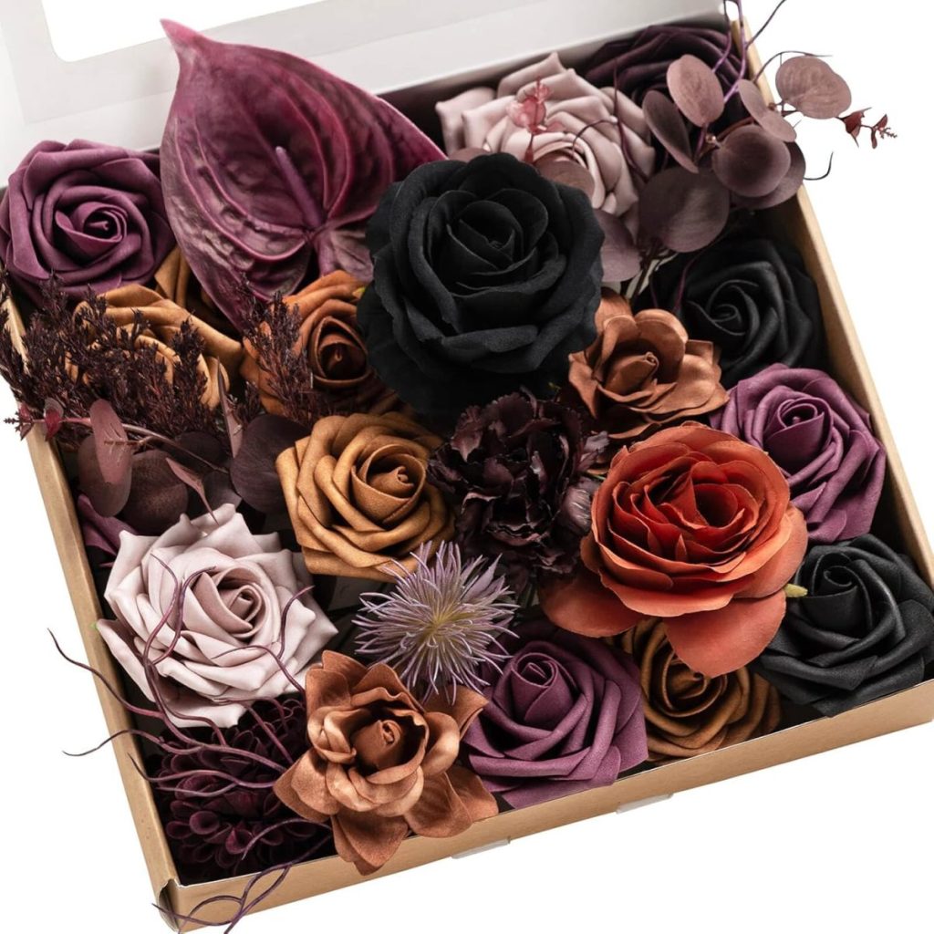 A rectangular box filled with an arrangement of artificial flowers in various colors, including black, purple, beige, and orange, perfect for creating a Halloween wreath.