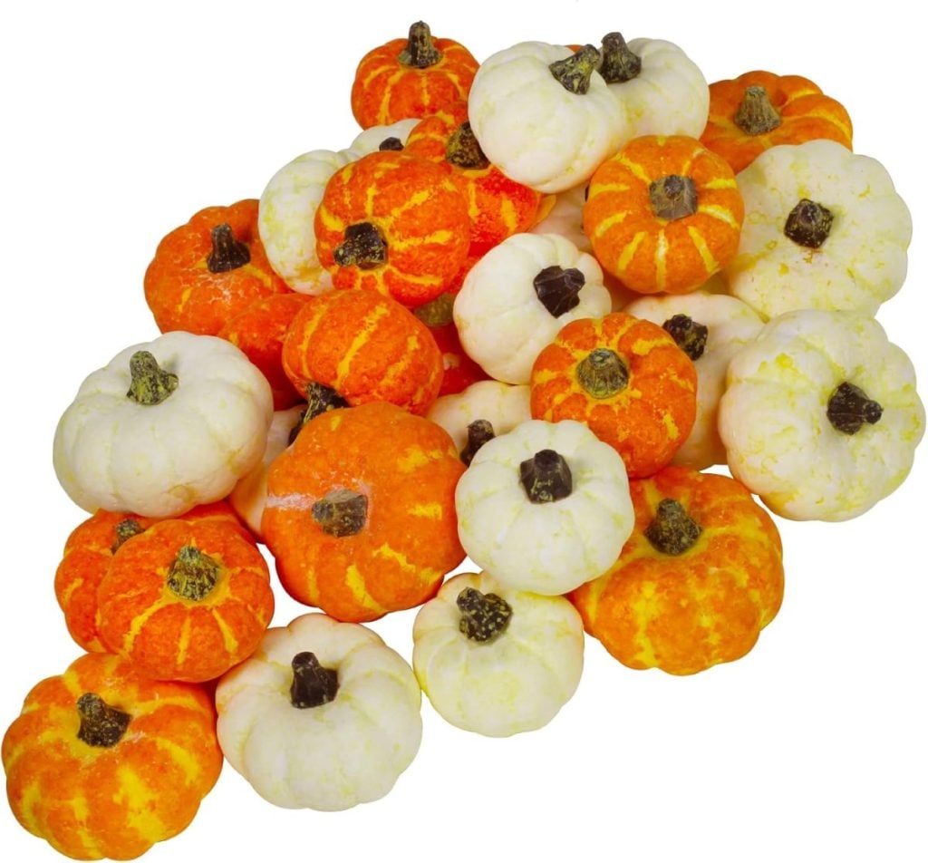 A pile of small white, orange, and striped pumpkins is gathered together, perfect for crafting a festive Halloween wreath.